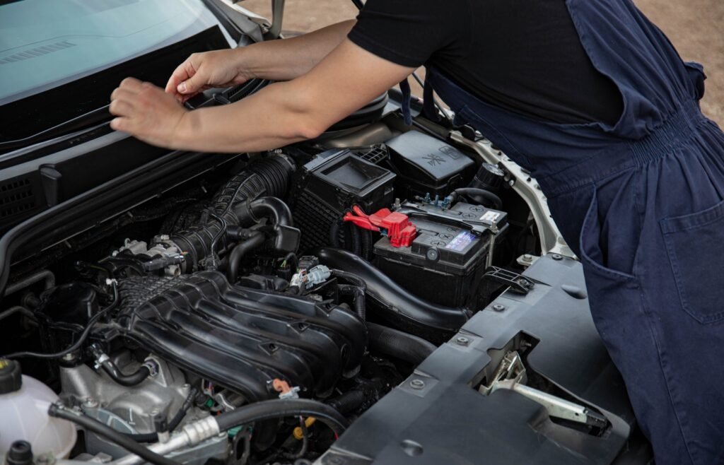 Mechanic working under the hood during car maintenance