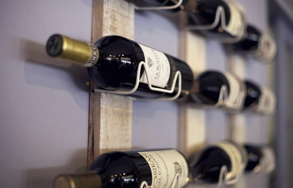 Wine bottles stored horizontally on a compact wall rack
